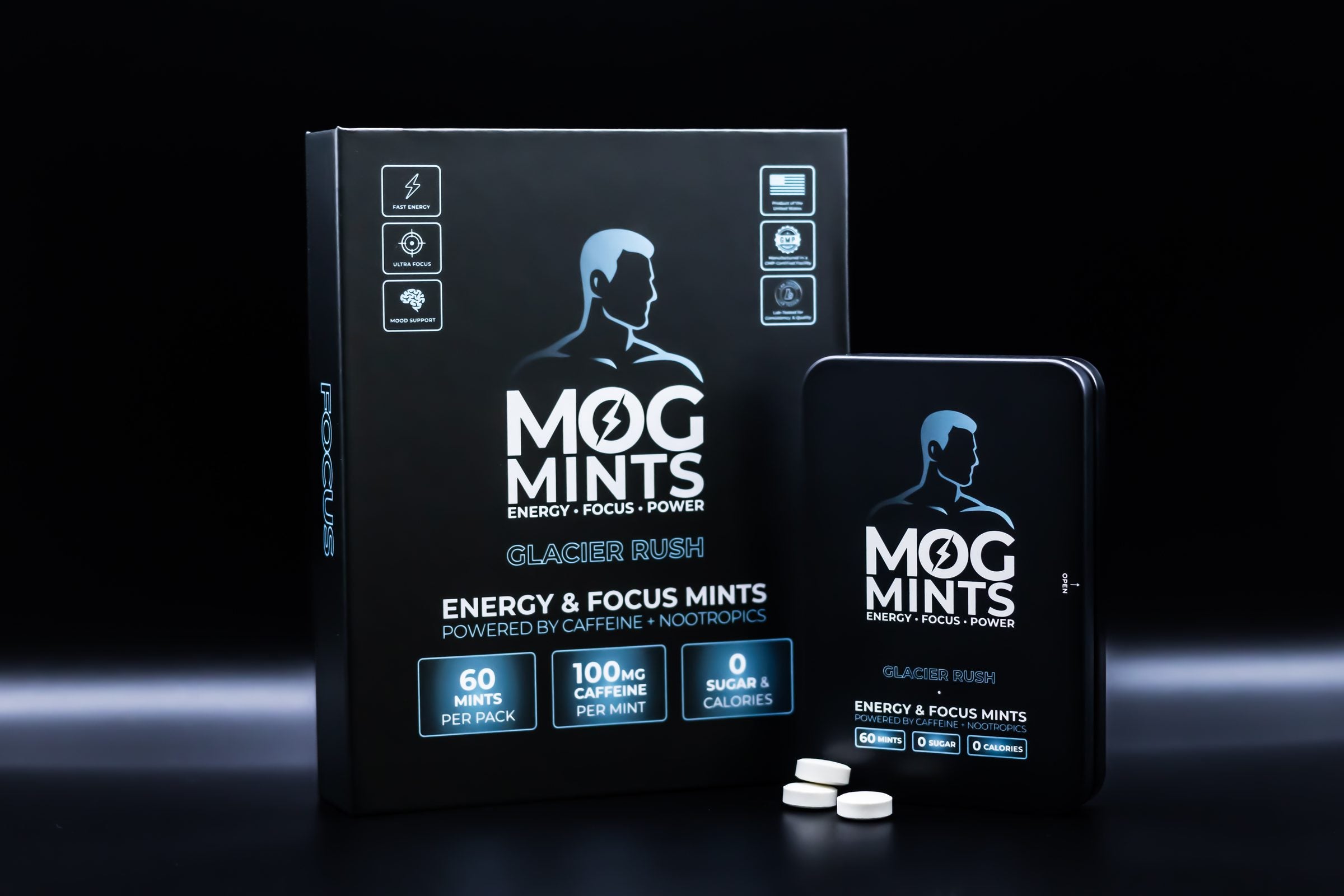 A MOG MINTS tin standing beside its box on a black surface, lit with a cold blue edge.